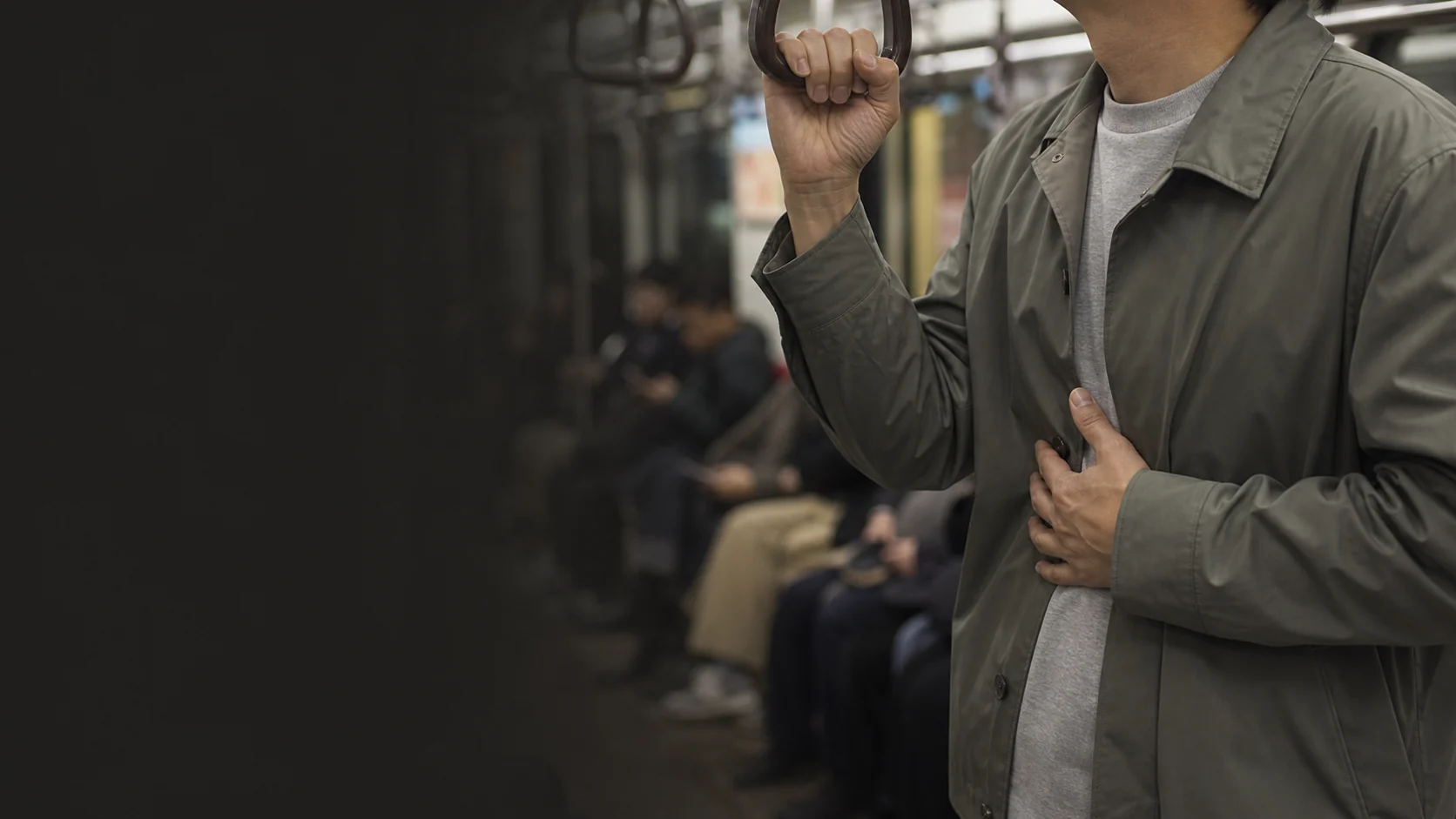 지하철 안에서 손잡이를 잡고 가슴의 갑작스러운 변화를 느끼는 성인의 손과 상반신